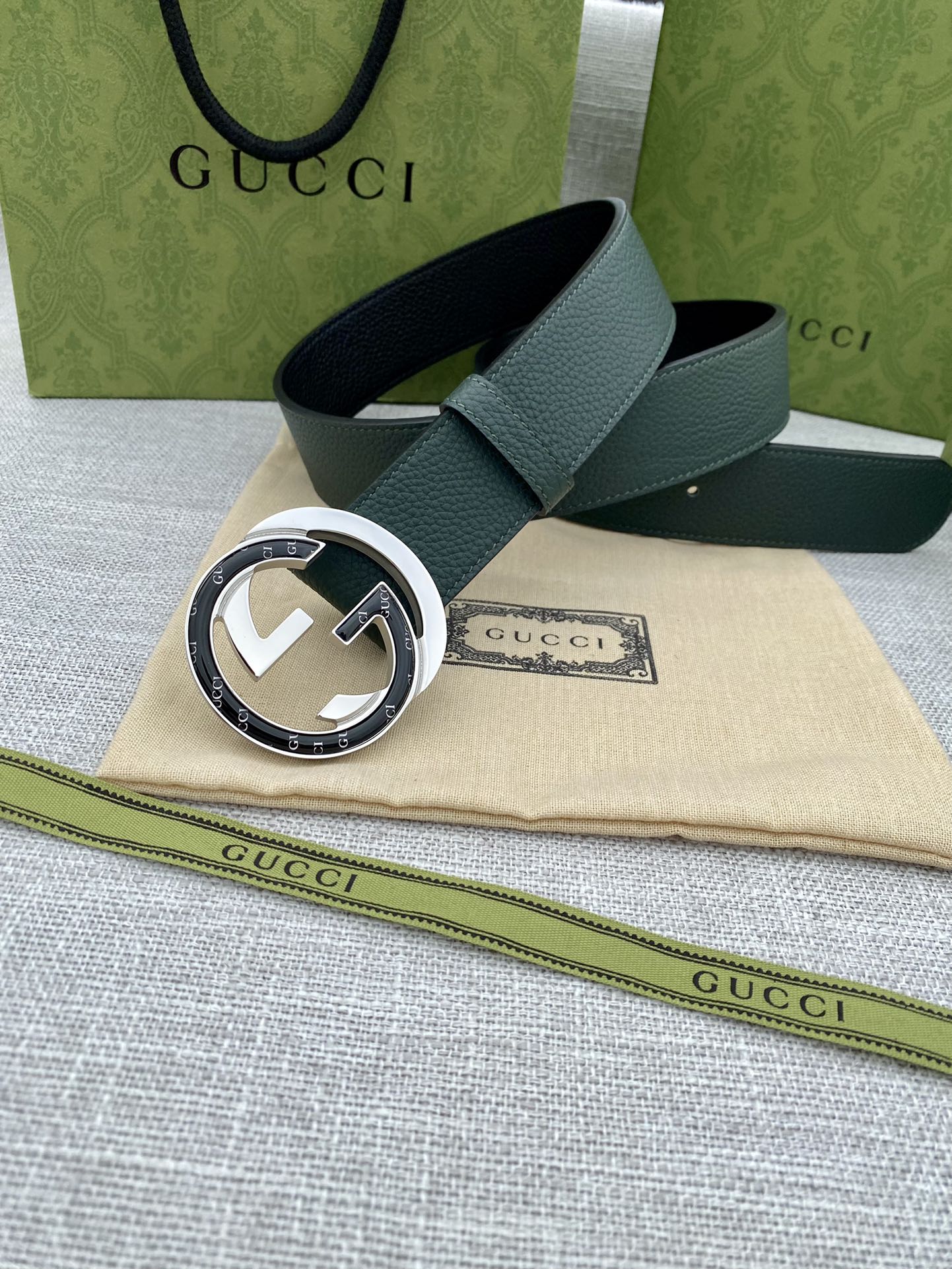 Gucci belt in dark green leather with round silver-and-gold GG buckle