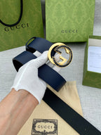 Navy leather belt with oversized gold-tone G buckle, styled with box and receipt