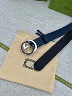 Navy leather belt with round G buckle on beige dust bag