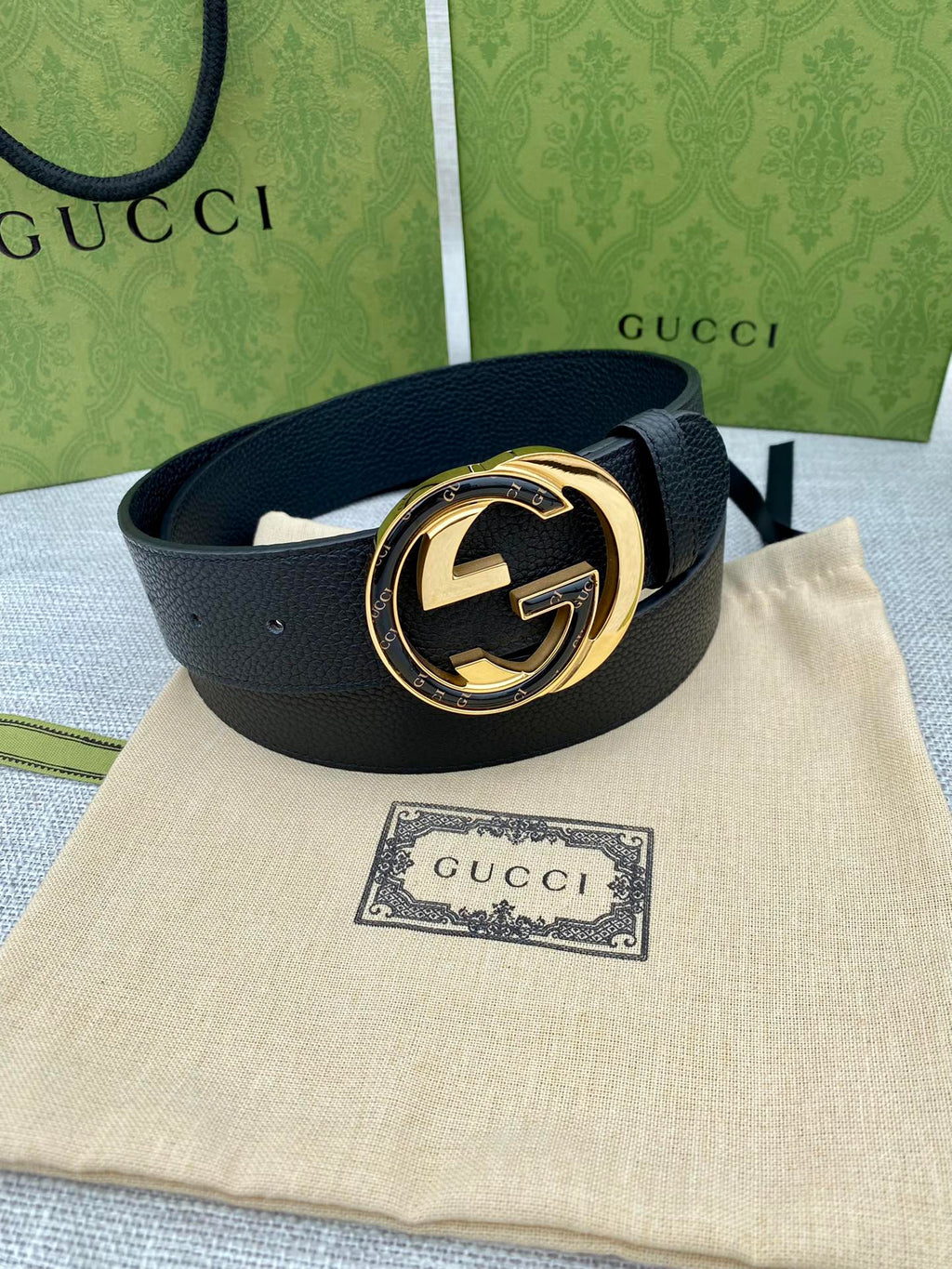Gucci belt with black leather strap and gold-tone circular GG buckle
