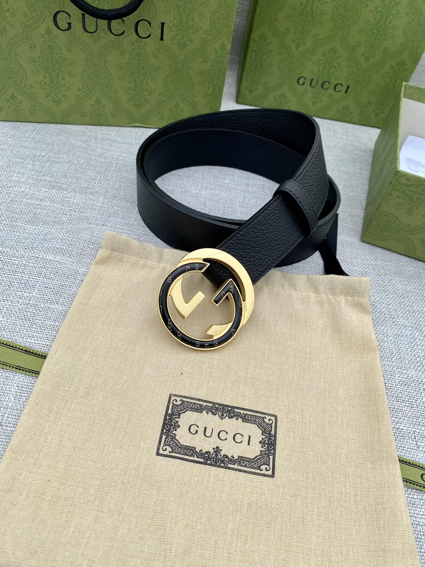 Black leather belt with gold-tone round double G buckle and attached strap