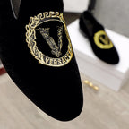 Versace black loafer close-up with gold embroidered logo crest