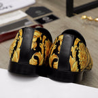 Luxury slip-on shoes heel view: black rubber sole with gold floral paneling