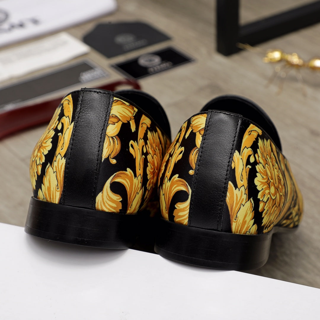 Luxury slip-on shoes heel view: black rubber sole with gold floral paneling