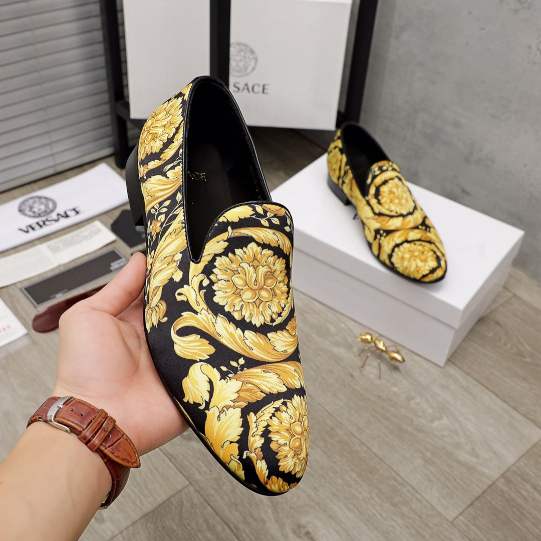 Luxury slip-on shoes, black with gold floral ornament print, curved apron detail