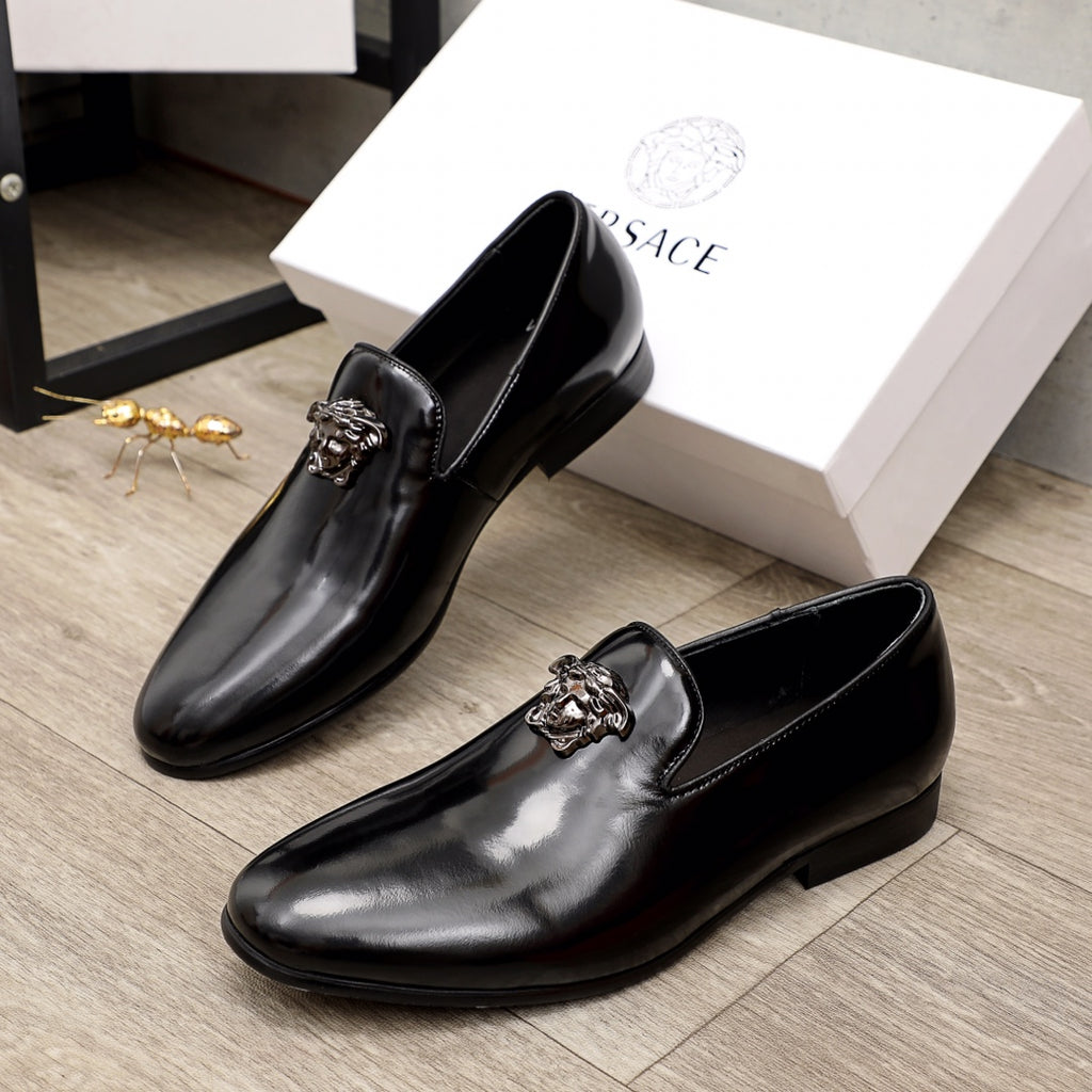 Versace black patent leather loafers with lion-head buckle detail, paired view