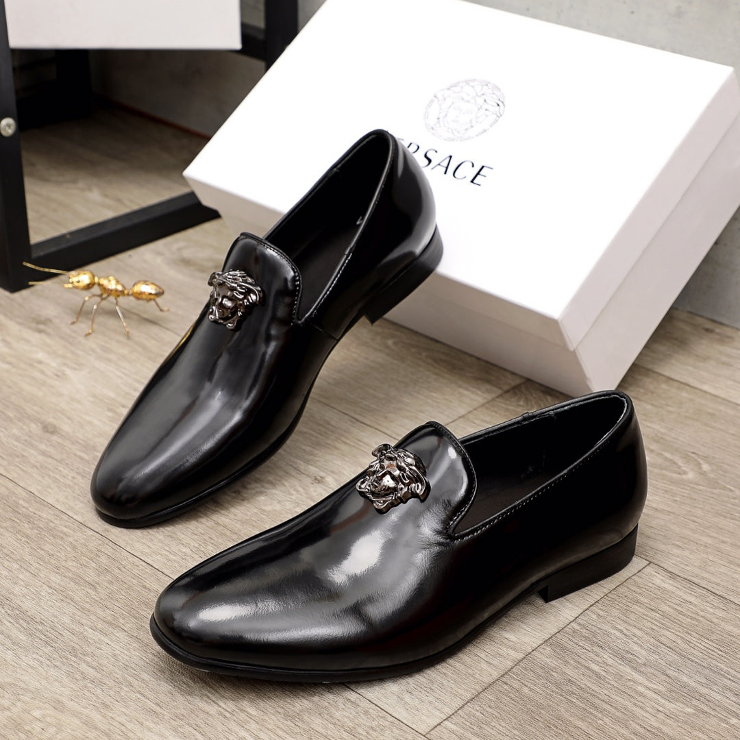 Versace black patent leather loafers with lion-head buckle detail, paired view