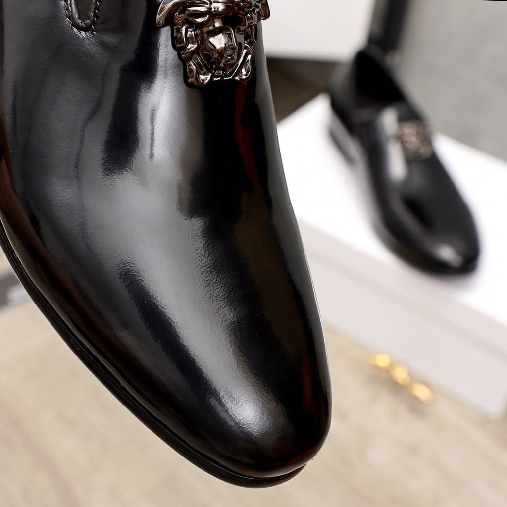 Versace black patent leather loafer toe with lion-head ornament, close-up
