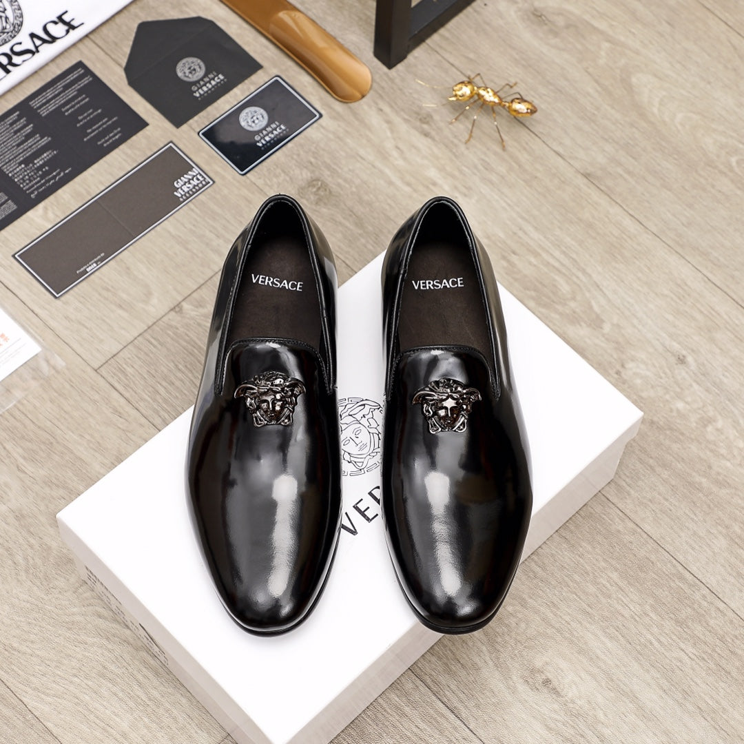 Versace black patent leather loafers with lion-head ornament and slip-on design