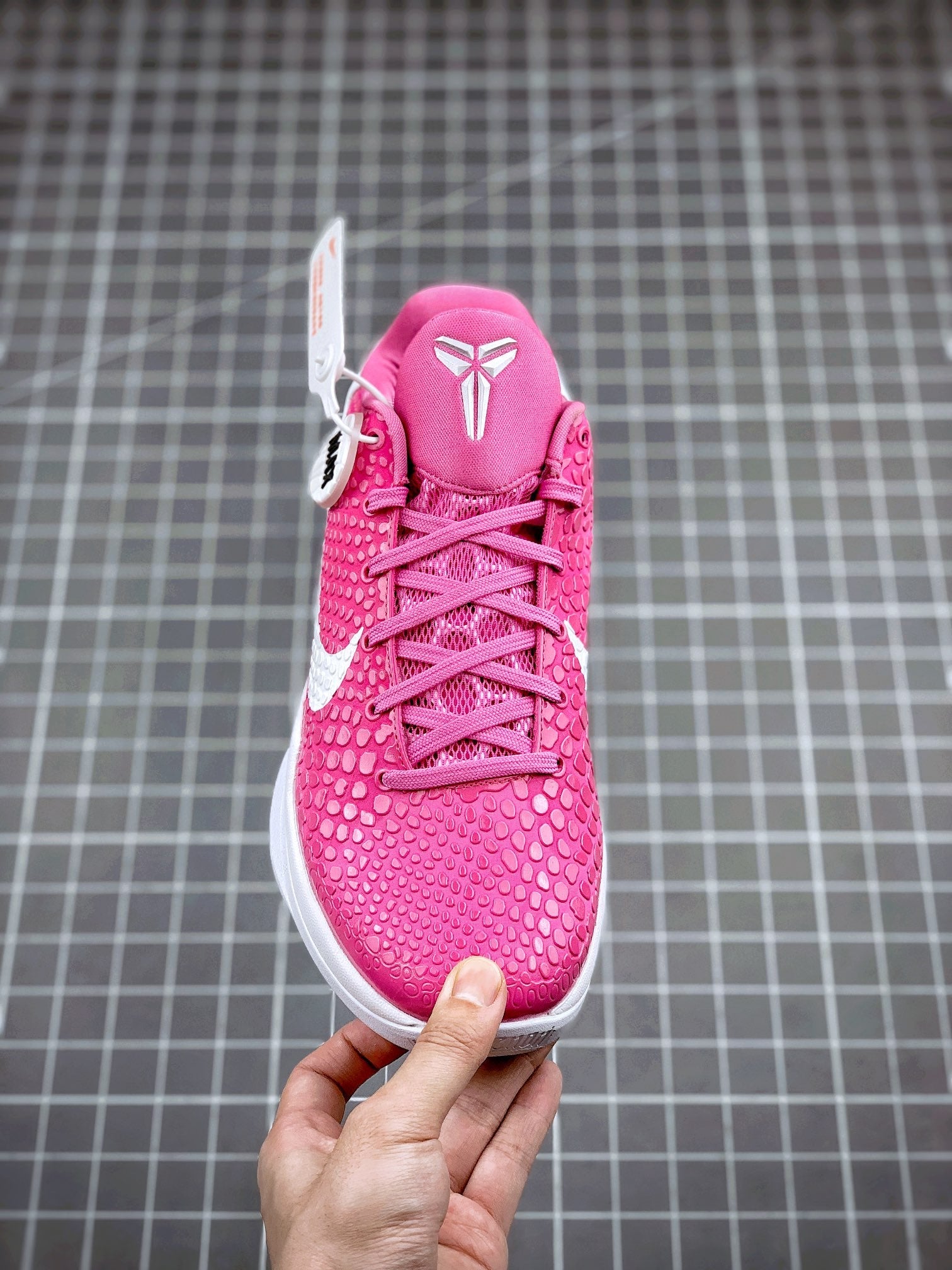 Pink lace-up basketball sneaker with white outsole and padded collar, side view