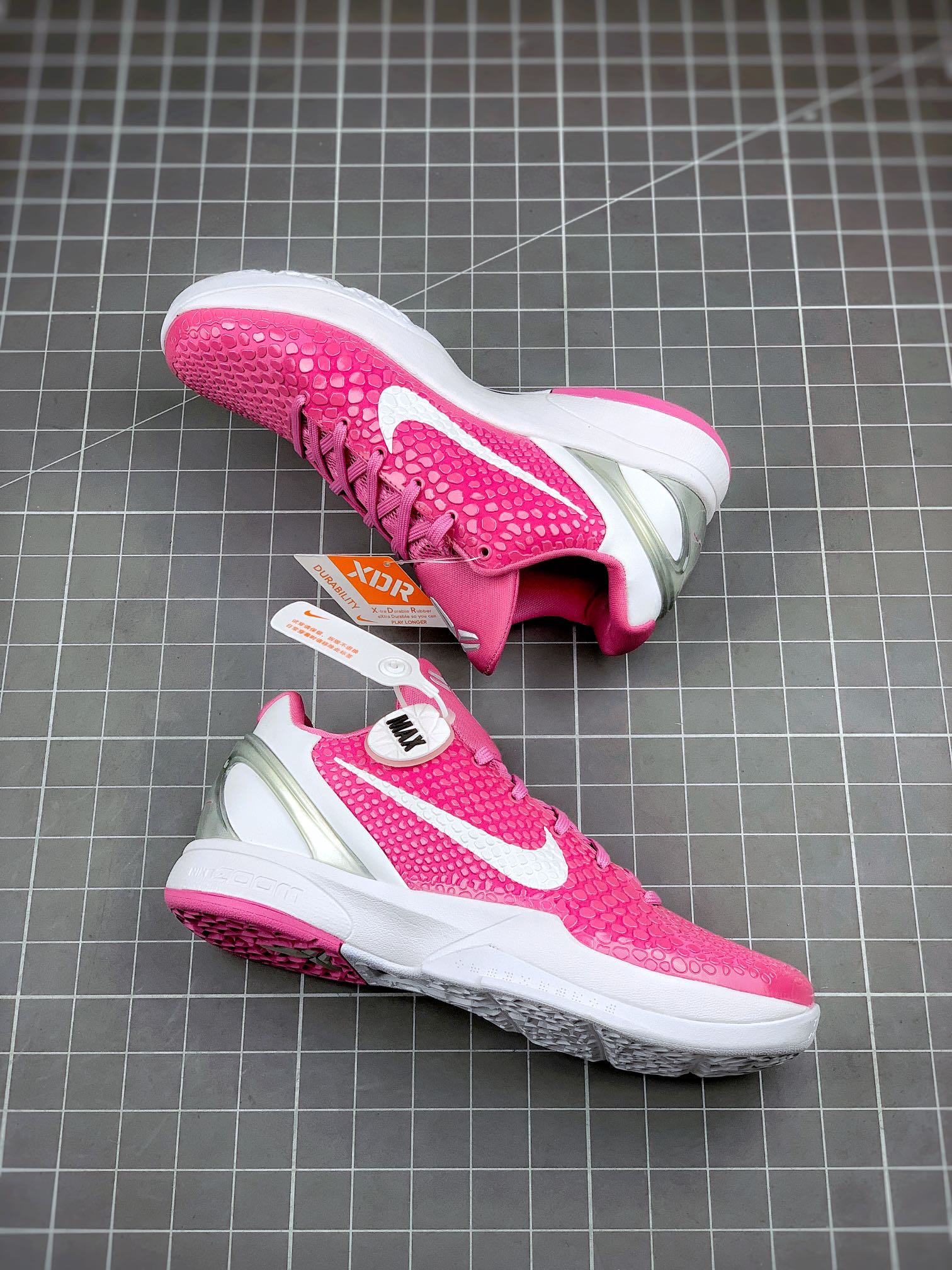 Pink basketball sneaker with white sole and textured outsole, toe and side view