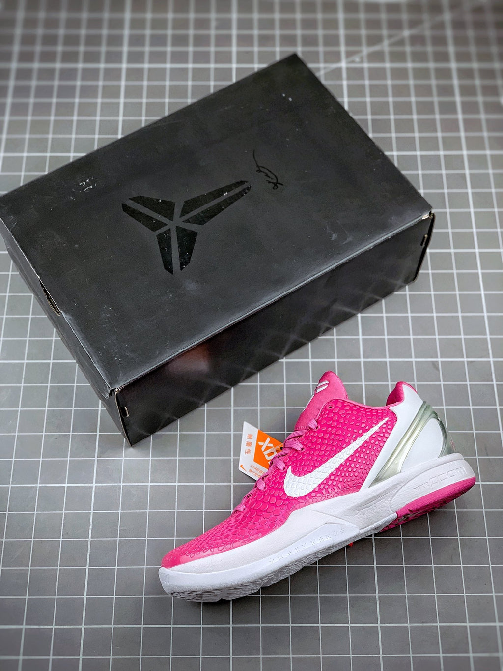 Pink basketball sneaker with white swoosh stripes and textured pattern, side angle