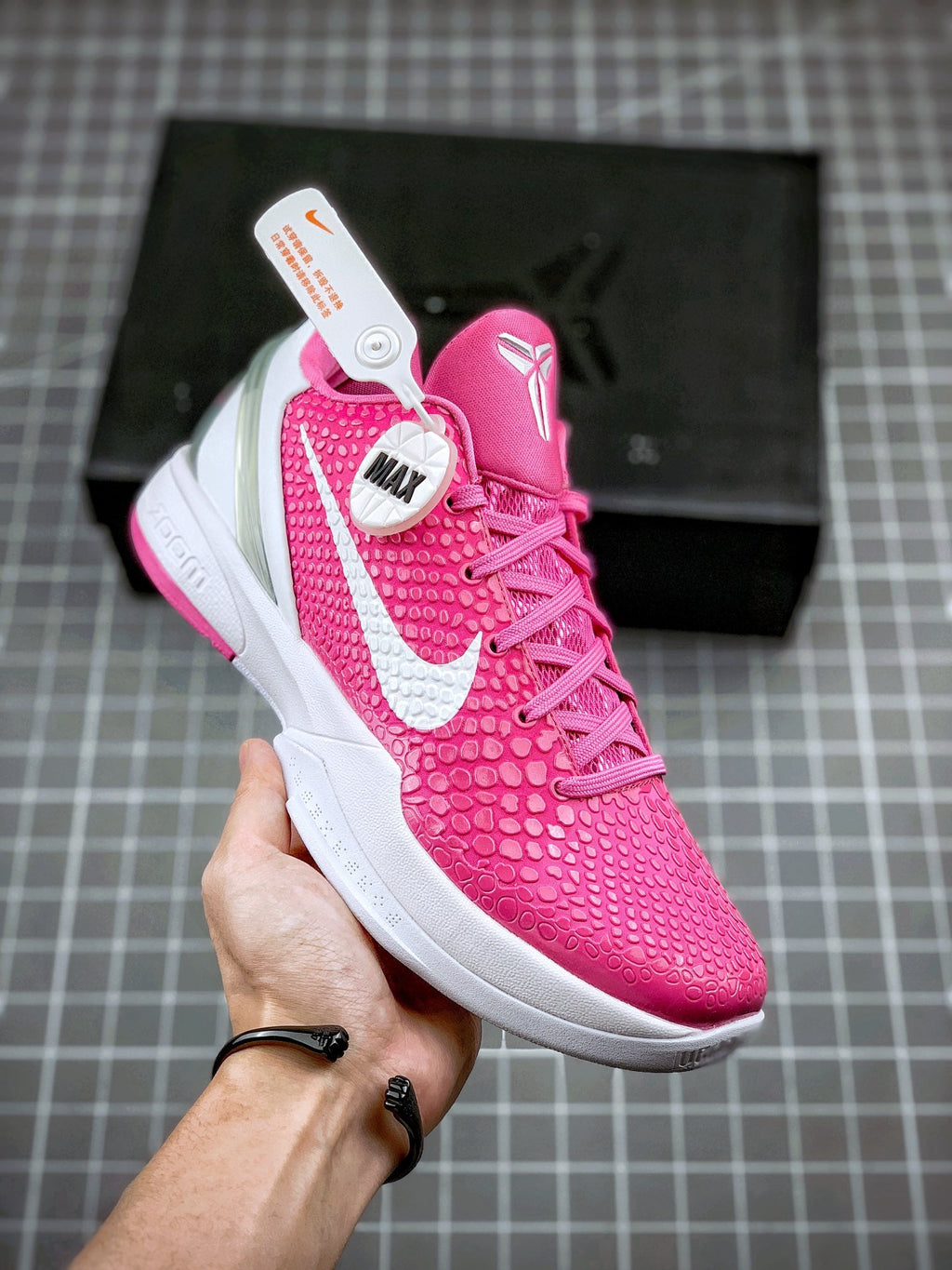 Pink basketball sneaker with white swoosh and textured upper, lace-up front view