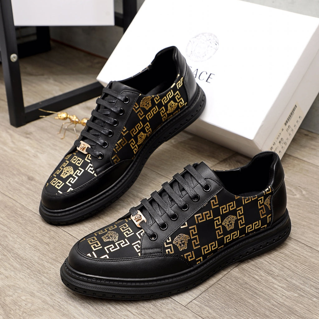 Versace lace-up sneakers in black with gold pattern panels and low-profile rubber sole