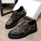 Versace lace-up sneakers in black with gold pattern panels and low-profile rubber sole