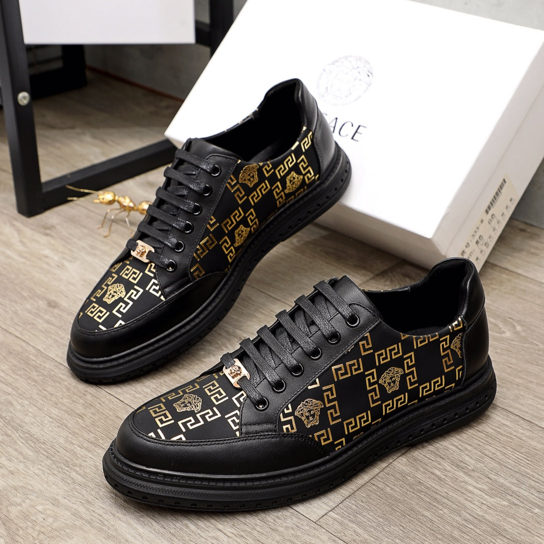 Versace lace-up sneakers in black with gold pattern panels and low-profile rubber sole