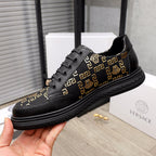 Versace low-top sneakers, black with gold medallion accents and Greek key patterned sides