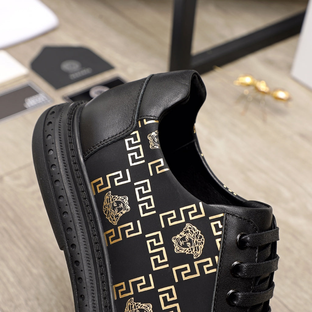 Versace sneakers side view, black leather with gold motif panel and lace-up closure