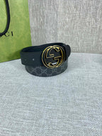 Gucci belt with dark strap and gold-tone double G buckle, curved round face