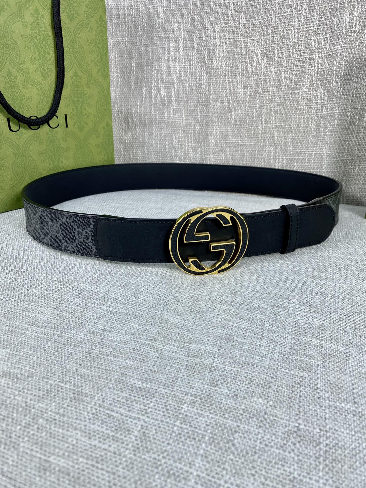 Gucci belt with dark canvas strap and gold-tone double G buckle, round shape