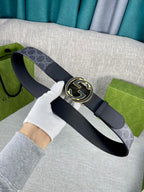 Gucci belt with navy monogram strap, gold-tone double G buckle on dark leather