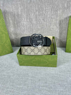 Gucci belt with dark strap and round GG logo buckle centered on the belt