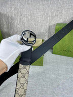 Gucci belt buckle close-up: round GG logo in black and silver on dark strap