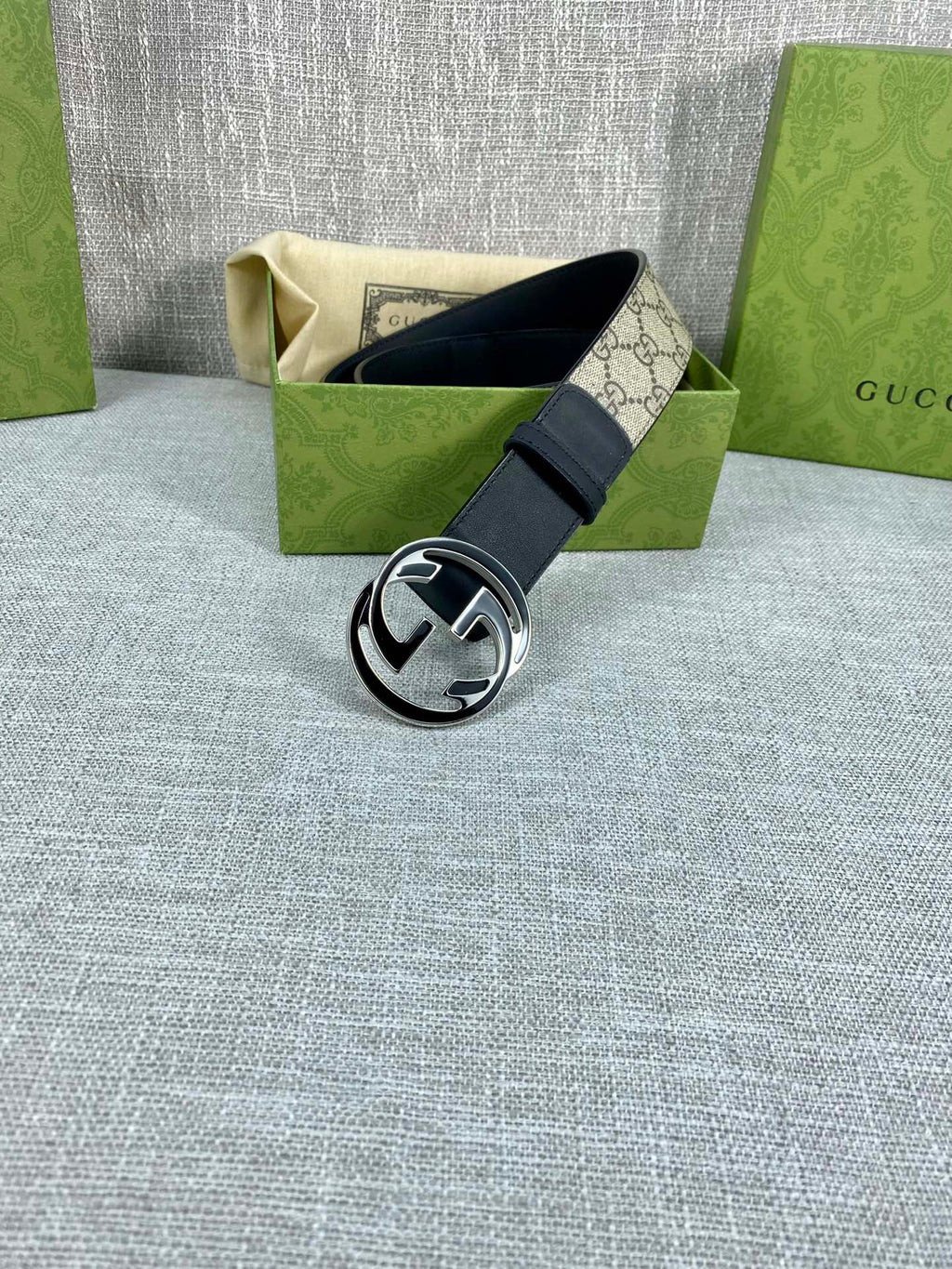 Gucci belt with dark leather strap and silver-toned round GG logo buckle