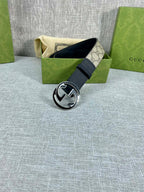 Gucci belt with dark leather strap and silver-toned round GG logo buckle