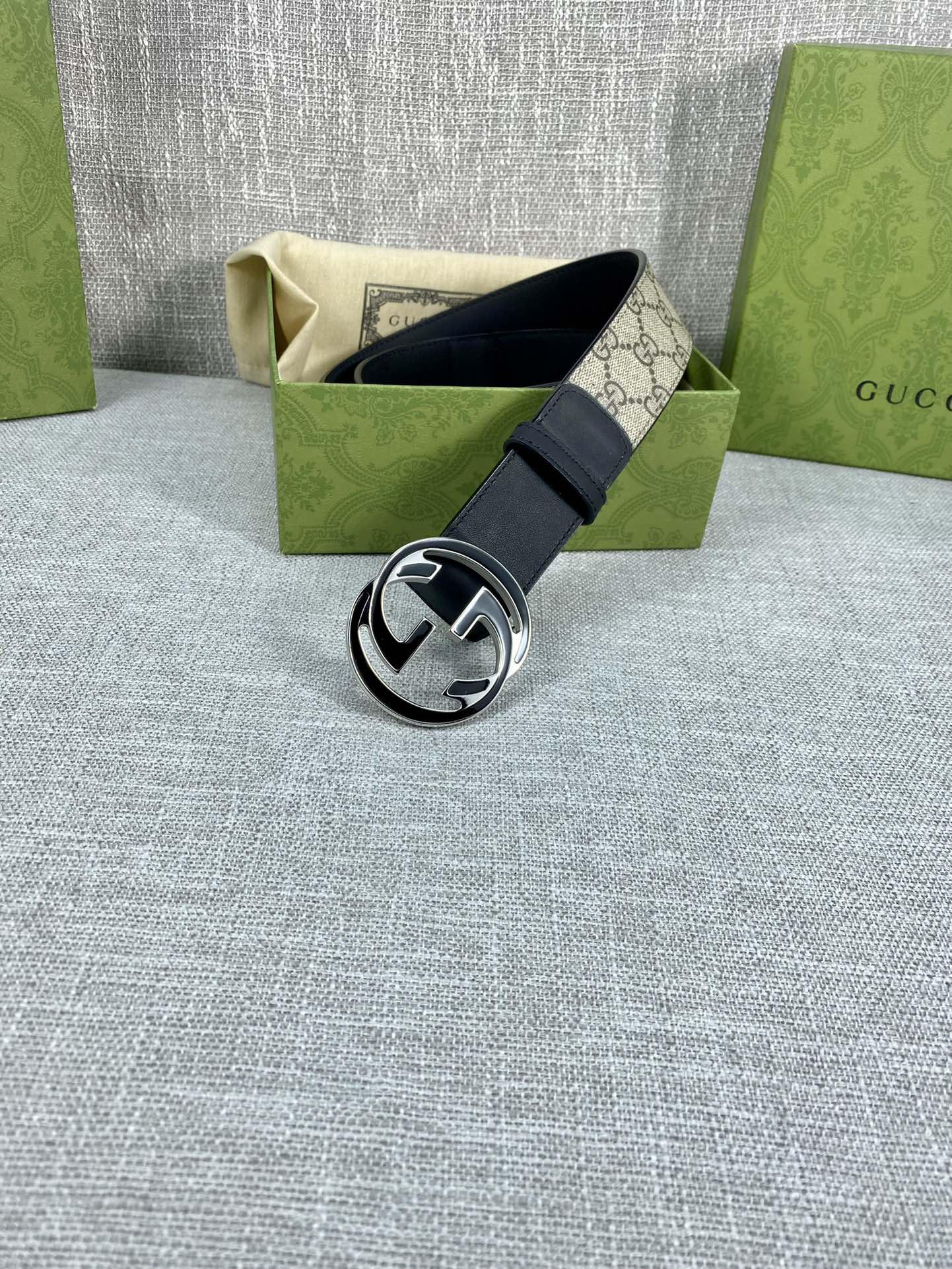 Gucci belt with dark leather strap and silver-toned round GG logo buckle