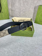 Gucci belt with dark strap and round GG logo buckle, belt end folded
