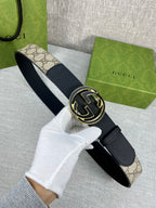 Gucci belt with dark strap and round GG logo buckle, worn end and clasp shown