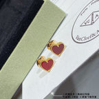 Heart stud earrings with red enamel and gold-tone crystal halo, pair on display