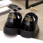 Black Versace sneakers, rear view with gold 'Couture' logo text on heel
