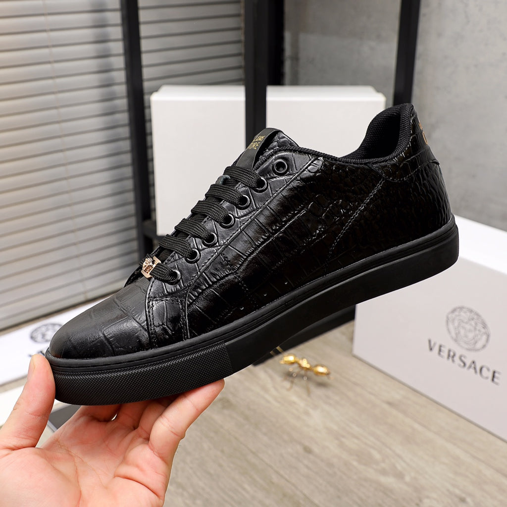 Black Versace low-top sneakers, textured leather and gold-toned hardware detail