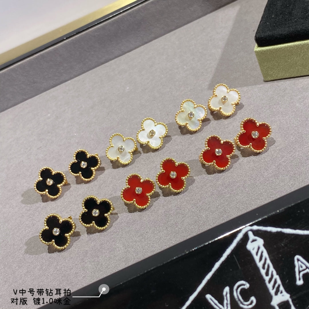 Clover-shaped stud earrings set with gold-tone outlines in white, black, red, and yellow