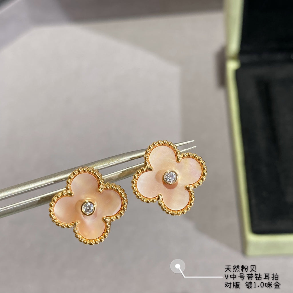 Gold clover stud earrings with white enamel petals and clear round center stones on earring posts