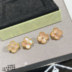 Gold clover stud earrings with white enamel petals and round clear center stones