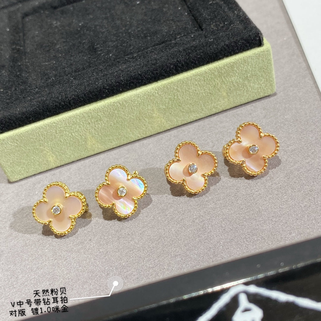 Gold clover stud earrings with white enamel petals and round clear center stones