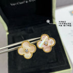 Gold clover stud earrings with white enamel petals and clear center stones on earring post