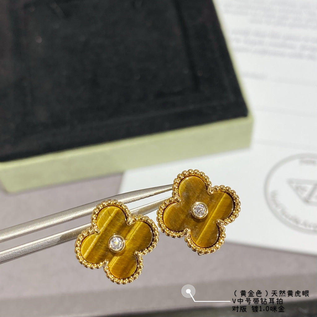 Gold clover stud earrings with yellow enamel and round crystal center on pin posts