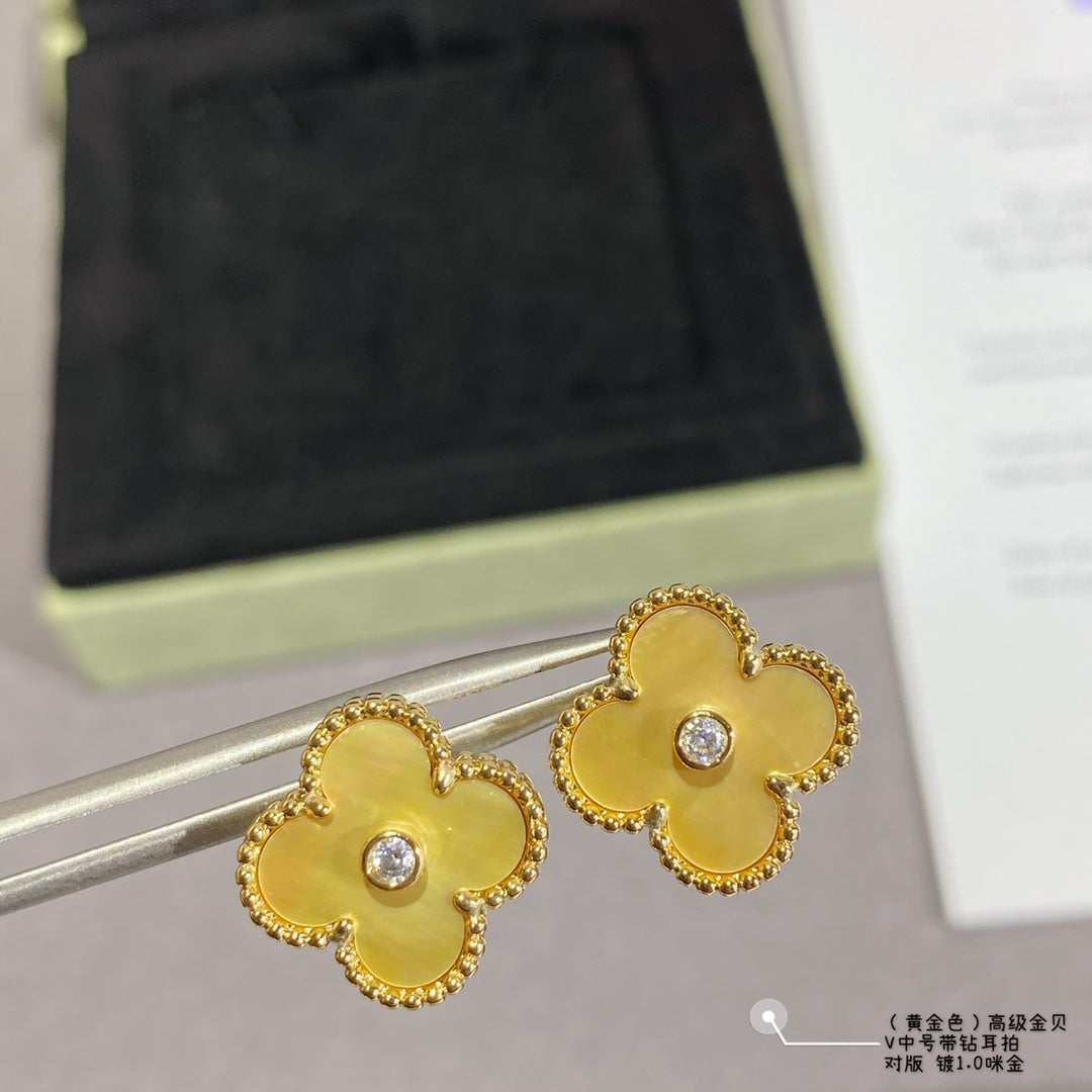 Gold clover stud earrings with clear stones, pair shown on metal posts.