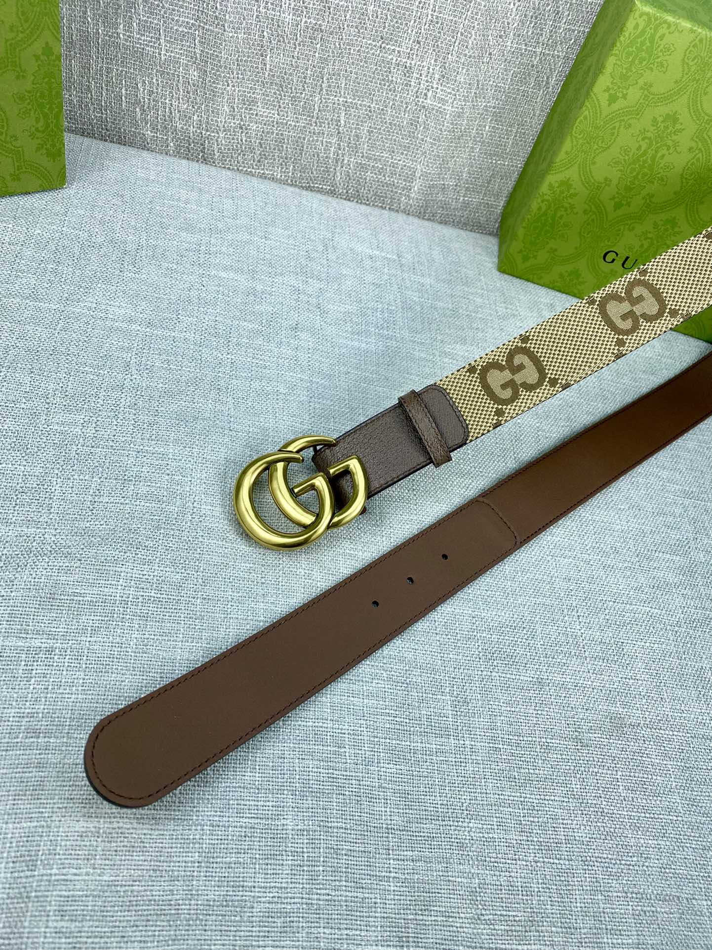 Gucci belt with beige GG canvas strap, gold buckle, dark brown leather underside