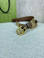 Gucci belt with beige GG canvas strap and gold double-G buckle on dark brown leather
