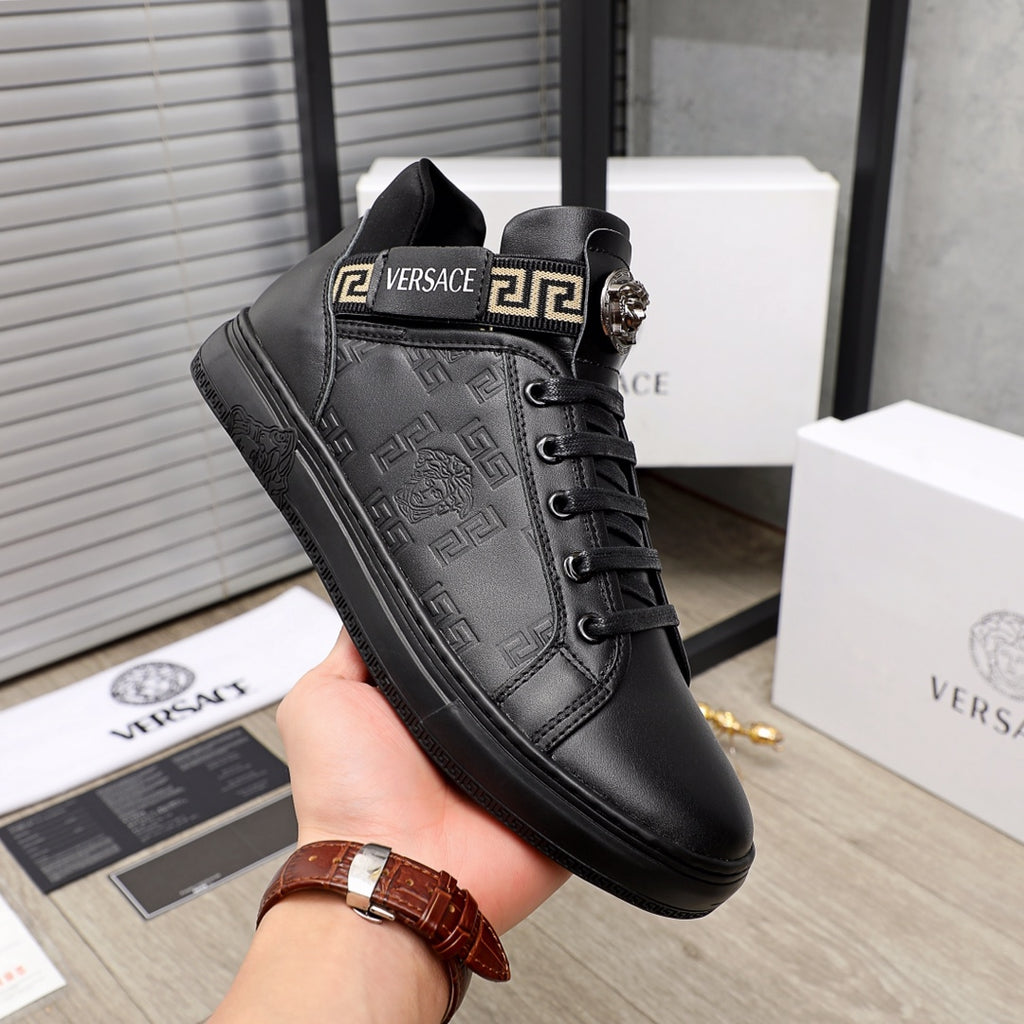 Black Versace high-top sneakers in hand; lace-up with logo strap detail