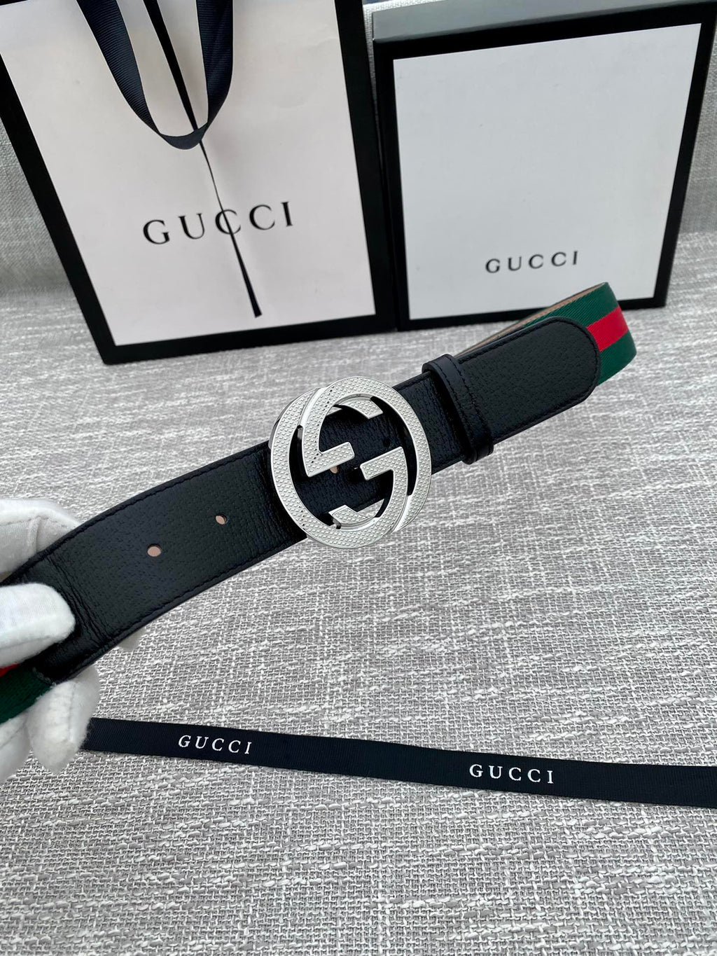 Black leather belt with silver GG buckle and green-red web stripe detail