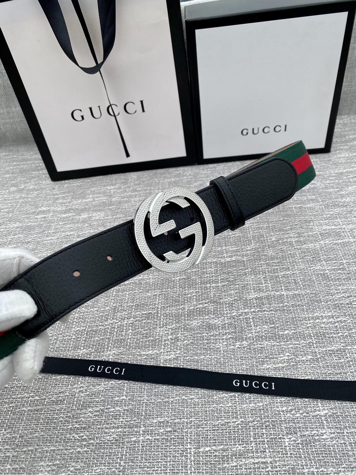Black leather belt with silver GG buckle and green-red web stripe detail