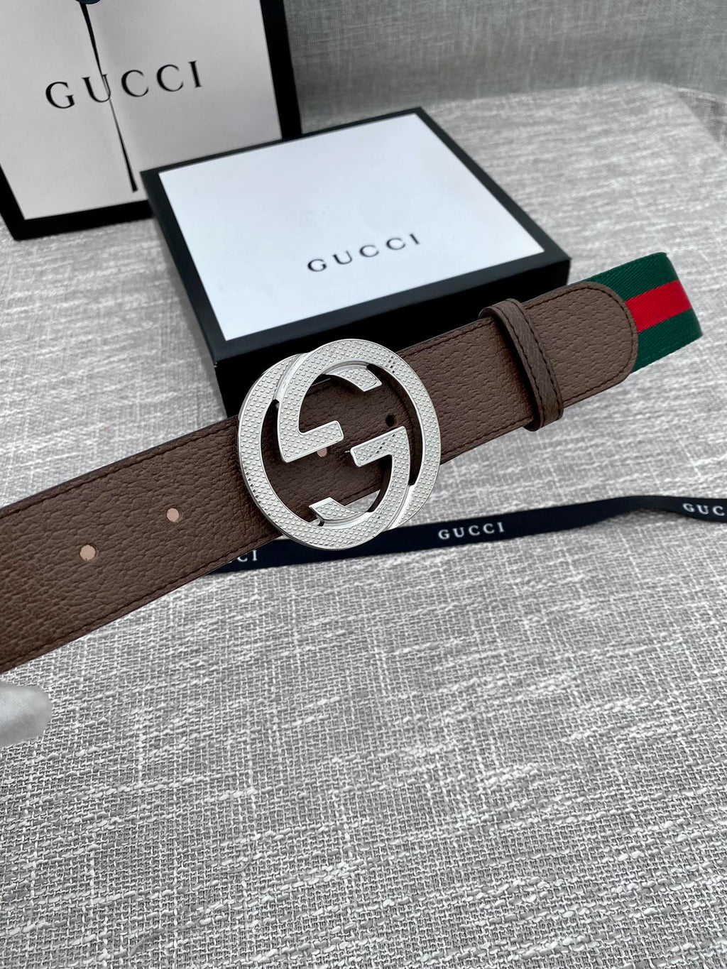 Brown leather belt with silver-tone GG buckle and green/red web stripe, on box
