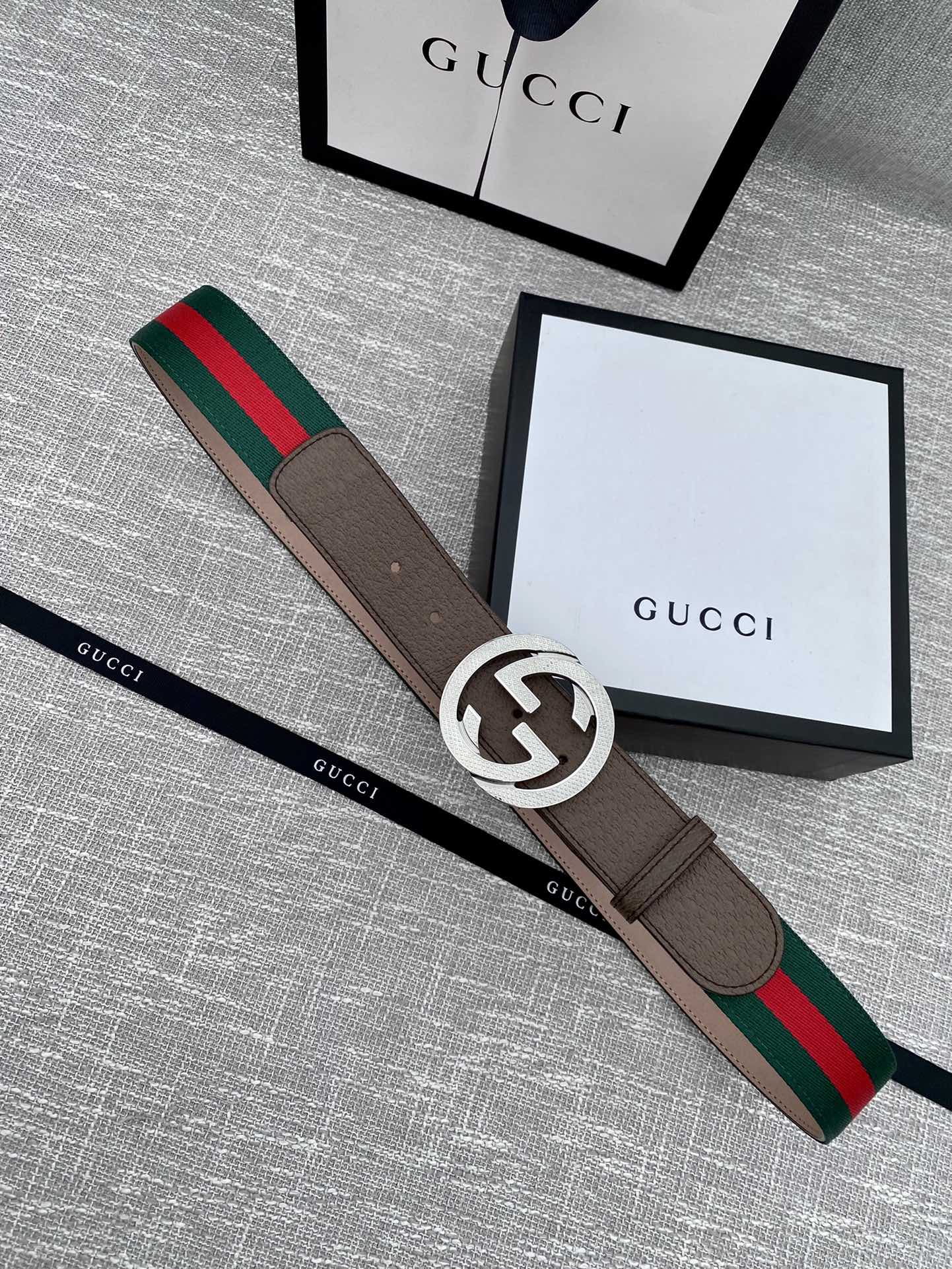 Brown leather Gucci belt with silver-tone GG buckle and green/red web stripe