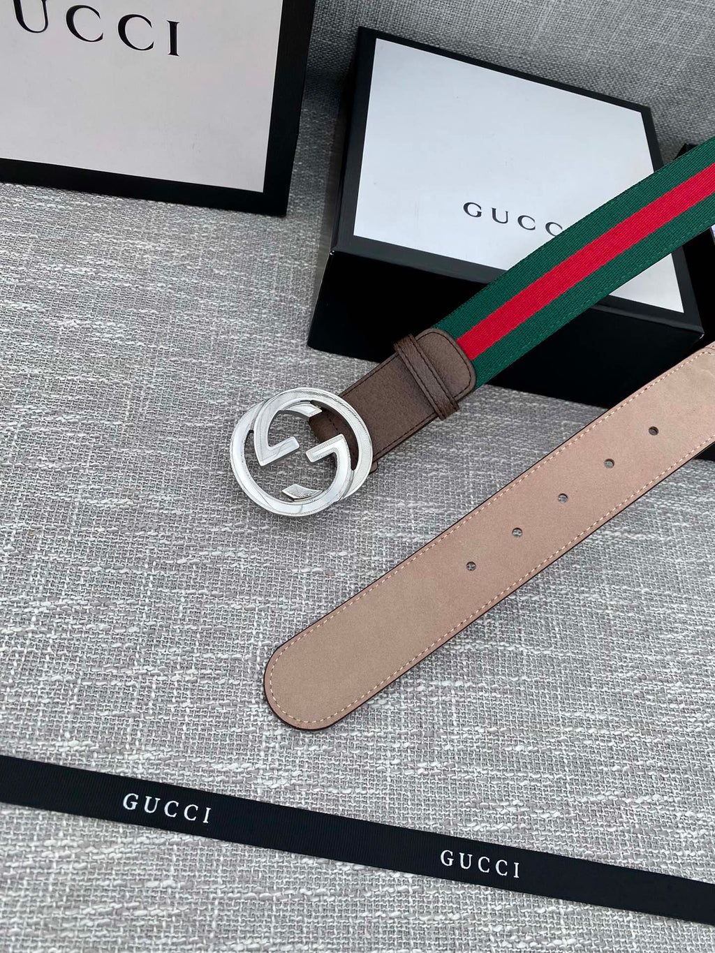 Gucci belt with brown leather strap, silver-tone double G buckle, and green-red stripe web edge.